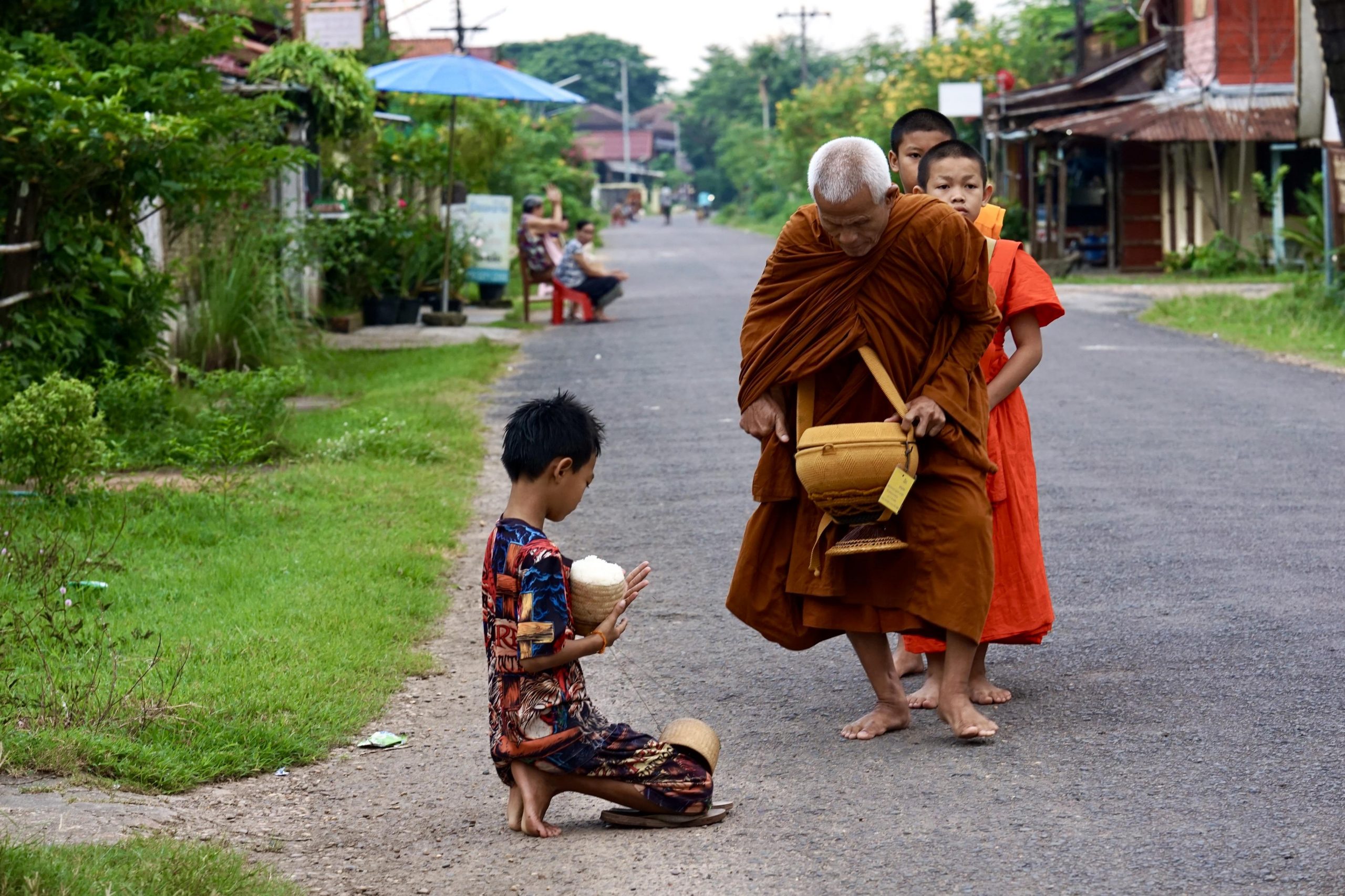 Almsgiving in champasak with monks receiving offers from people